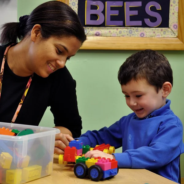 Northern Virginia Academy of Early Learning - Two Year Old program - image of teacher and child building with connective toy blocks