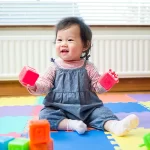 Infant Daycare - Northern Virginia Academy of Early Learning - cute baby playing with soft colored blocks