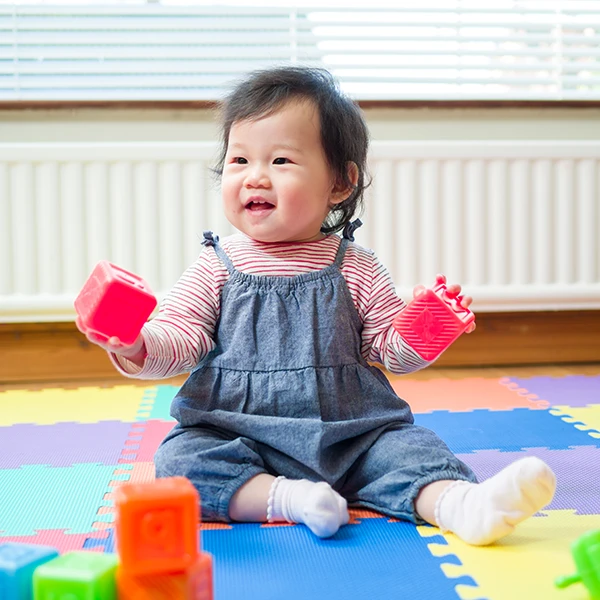 Infant Daycare - Northern Virginia Academy of Early Learning - cute baby playing with soft colored blocks