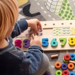 Preschool for Three Years Olds - Northern Virginia Academy of Early Learning - photo of child counting with numbered wooden blocks